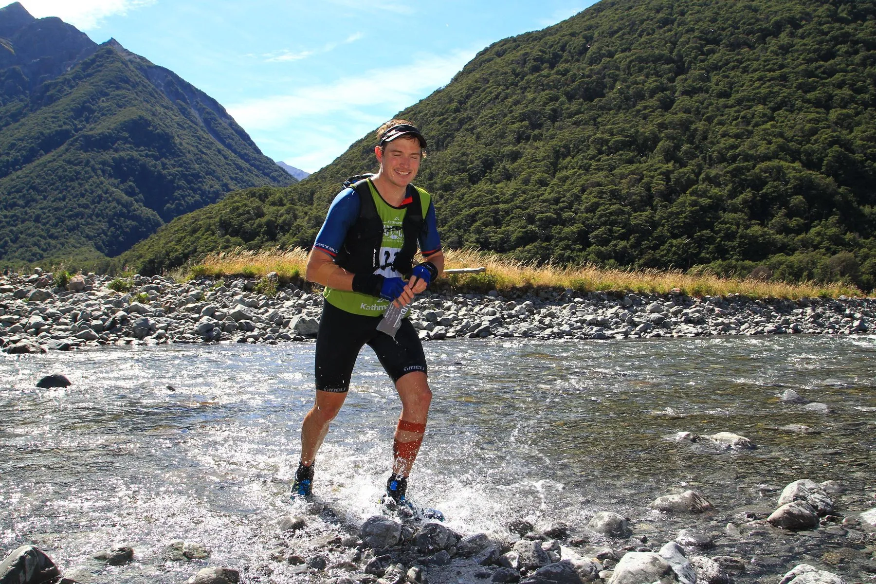 Alastair running through a braided river during an adventure race